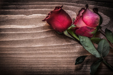 Red roses on wooden board holidays concept