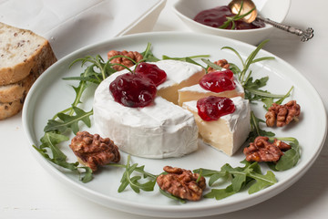 Camembert. Camembert cheese on the plate with cowberry sauce.