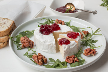 Camembert. Camembert cheese on the plate with cowberry sauce.