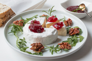 Camembert. Camembert cheese on the plate with cowberry sauce.