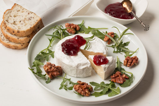 Camembert. Camembert cheese on the plate with cowberry sauce.