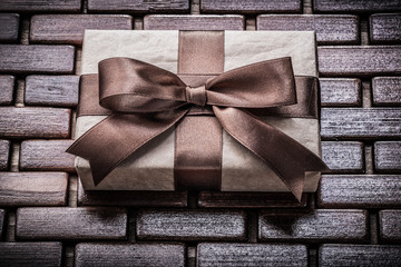 Wrapped giftbox with ribbon on wooden wicker matting holidays co
