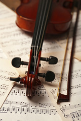 Naklejka premium Violin neck on music papers background