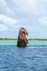 ein Teil eines Schiffswracks ragt aus dem Wasser
