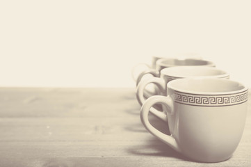 The black-and-white photo of the cups standing on the edge of a