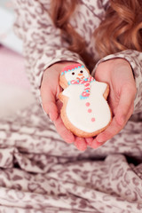 Fototapeta na wymiar Girl holding snowman gingerbread closeup. Christmas cookies. 