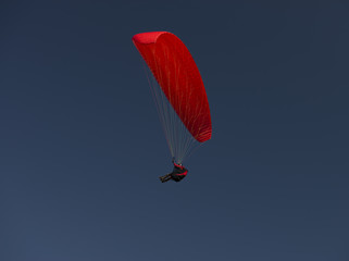 red paraglider on clear blue sky