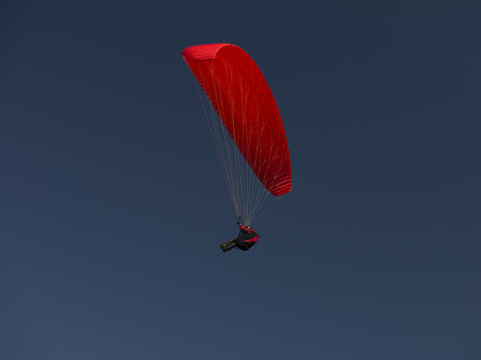 red paraglider on clear blue sky