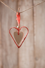 handmade heart hanging over wooden background