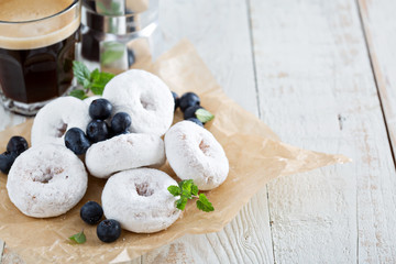 Powdered sugar donuts on parchment