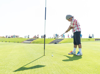 Obraz premium Kid playing golf at club