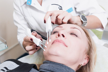 beautiful girl beautician making permanent makeup on woman's face. Blonde. doctor.