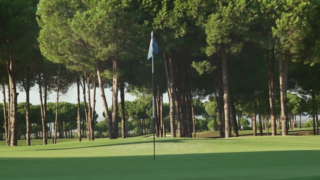 young healthy golfer hitting golf shot with club on course