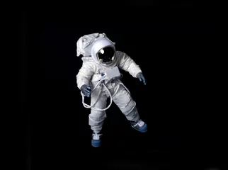 Abwaschbare Fototapete Jungenzimmer Astronaut, der gegen einen schwarzen Hintergrund schwimmt.