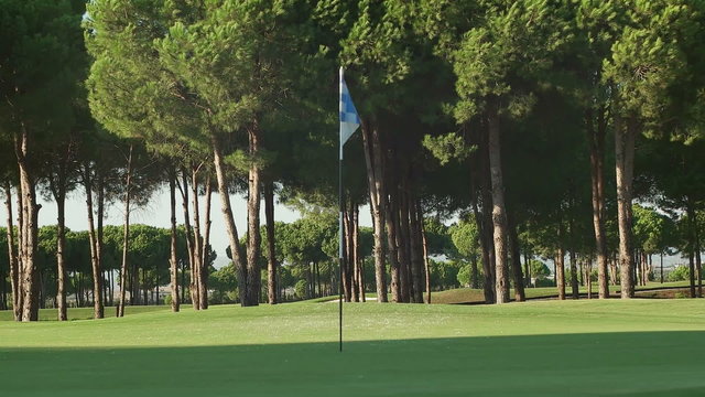 young healthy golfer hitting golf shot with club on course