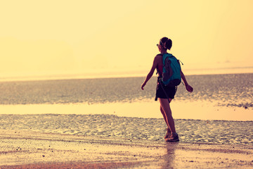 young woman hiking on sunrise beach