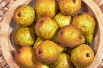 ripe pears in a wooden bowl.