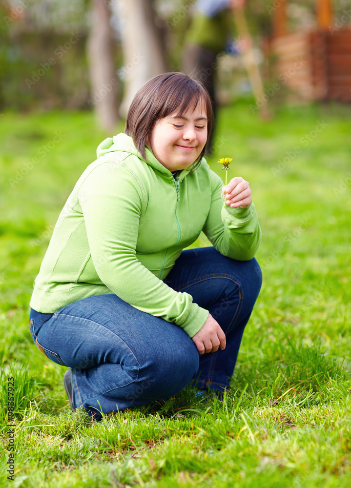 Wall mural young adult woman with disability enjoying nature in spring garden