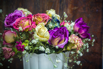 vintage colorful preserved roses on dark tone wooden background