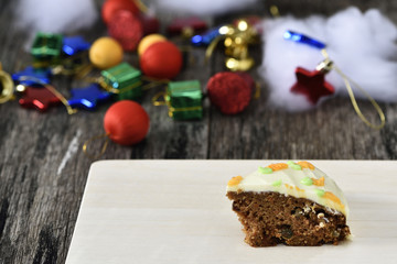 Slice carrot cheese cake on wood plate in christmas background
