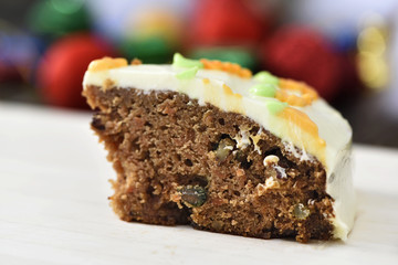 Slice carrot cheese cake on wood plate in christmas background
