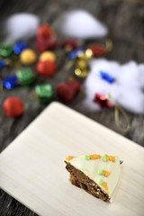 Naklejka na ściany i meble Slice carrot cheese cake on wood plate in christmas background