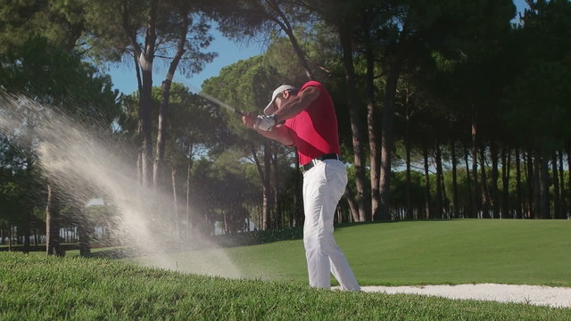 young healthy golfer hitting golf shot with club on course