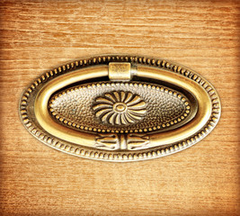 antique drawer handle on wood background