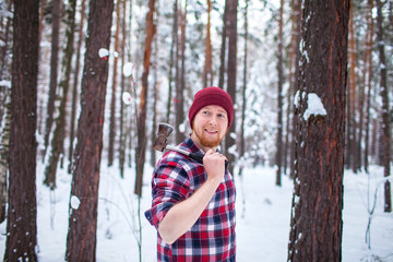 bearded man with an hatchet in the winter forest