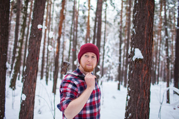 bearded man with an hatchet in the winter forest