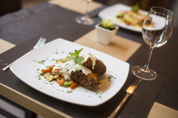 Grilled meat with sauce and herbs served at restaurant