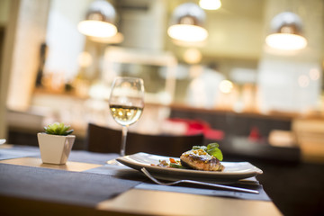 Grilled salmon with sauce and herbs served at restaurant