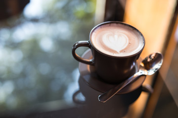 Hot art Latte Coffee in a cup on wooden table.