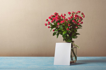 Bouquet of roses with a blank greeting card
