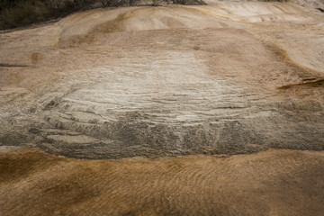 Mounds of travertine rock with orange geothermal pools, Yellowstone National Park, Wyoming.