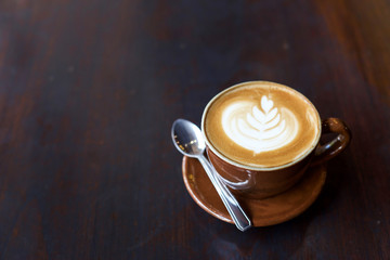 Hot art Latte Coffee in a cup on wooden table.