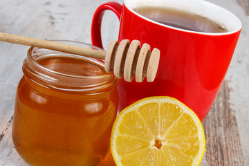Fresh lemon with honey and cup of tea on wooden table, healthy nutrition