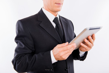 A man holding a modern laptop and reading news