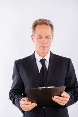 A portrait of focused man, who is working with clipboard