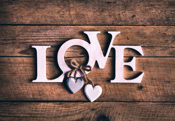 Wooden letters forming word LOVE written on wooden background. St. Valentine's Day. two hearts - 98366578