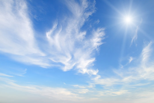 sun on blue sky with white clouds