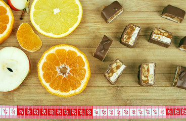 background of sweets, fruit, and a ruler on a wooden board