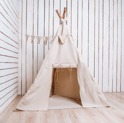 wigwam in a room with wooden planked walls © tan4ikk