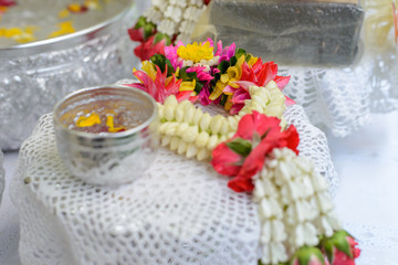 Thai garland Flowers and Water with jasmine and roses corolla in bowl on golden tray (Use for Songkran festival in Thailand)