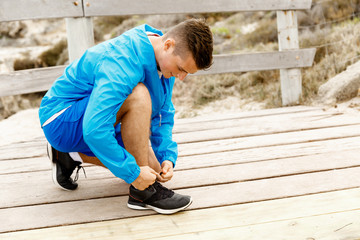 Runner laces his shoes and prepares to jogging
