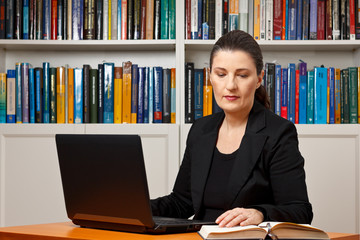 woman office laptop reading book