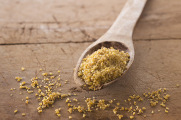 bulgur biologico su cucchiaio legno e fondo legno