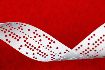 Closeup of perforated punched tape on blue background