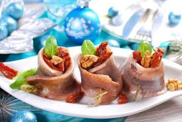 appetizer of herring rolls with dried tomato and walnuts for chr