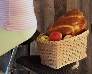 basket by bicycle with apples and pastries